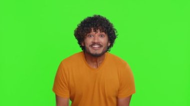 Mutlu Hintli adam bağırıyor, el kol hareketi yapıyor başarıyı kutluyorum, kazanıyorum, doğum günü, piyango vuruşu hedefliyorum, iyi haberlerim var. Yeşil krom anahtar geçmişi olan genç Hintli adam.