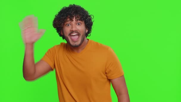 年轻的印度人从下面出现 挥挥手打招呼 欢迎有好客表情的人表达积极的情感 用绿色彩色键背景隔离的印度教男子 — 图库视频影像