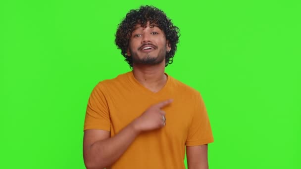 我选择了你快乐的印度年轻人指着相机 带着顽皮的快乐表情看着 做出了正确的选择 指明了方向 兴奋的后生家伙被绿色的彩色背景隔离了 — 图库视频影像