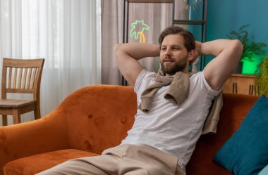 Yorgun bir adam rahat kanepeye uzanıp dinleniyor, gündüz uyukluyor. Tasasız beyaz adamın portresi, kafasının arkasında el ele tutuşmuş, evinde kanepede uyuyakalmış.