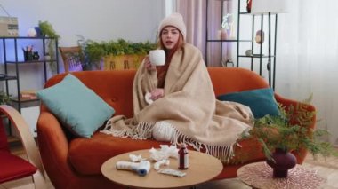 Soğuk algınlığı ya da alerji yüzünden acı çeken genç hasta kadın oturma odasında sıcak çay içiyor. Hasta kızıl saçlı kız ekose darbelere sarılı şapka giyiyor hapşırıyor sümükleri peçeteye sarıyor. Karantina