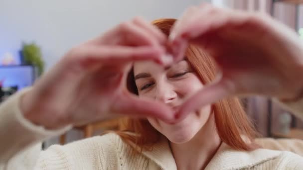 Αγαπώ Ευτυχισμένη Κοκκινομάλλα Γυναίκα Στο Σπίτι Καθιστικό Καναπέ Κάνει Σύμβολο — Αρχείο Βίντεο