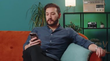 Lübnanlı adam evde otururken cep telefonuyla gülümsüyor. İnternet üzerinden akıllı telefon sosyal medya uygulamaları üzerinden mesajlaşan Arap bir adam, rahatlama filmi izliyor