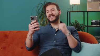 Hüzünlü Lübnanlı adam akıllı telefon daktilo kullanıyor. Ani piyango sonuçlarını kaybediyor. Kötü haber, servet kaybı, son teslim tarihi, virüs. Evdeki kanepede oturan genç Arap adam.
