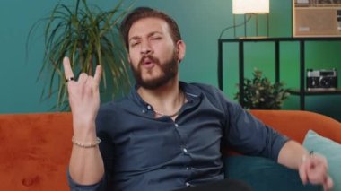 Neşeli genç Lübnanlı adam elleriyle rock 'n roll hareketi sergiliyor, havalı bir işaret, çılgın bir ifadeyle evet diye bağırıyor, dans ediyor. Arap adam sınıf kanepede duygusal olarak başarıyla seviniyor.