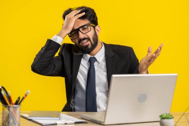 Memnuniyetsiz Hintli işadamı başarısızlık nedenini soruyor. İnançsızlığını dile getiriyor. Hayal kırıklığına uğradığını düşünüyor. Resmi takım elbiseli Hindu adam dizüstü bilgisayarla çalışıyor.