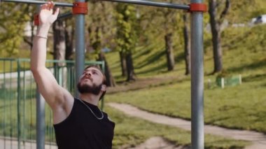 Spor giyimli atletik Lübnanlı adam yatay barda egzersiz yapıyor. Genç adam yaz parkında sırt kaslarını şişiriyor. Spor, sağlık, spor, egzersiz. Güç, motivasyon.
