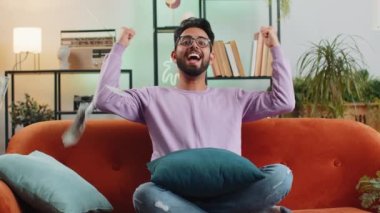 Hindistan 'da başarı, galibiyet, gol başarısı, iyi haber, piyango ikramiyesi, ev içinde hayaller gerçek oluyor. Kariyer büyür. Adam kanepede oturuyor.