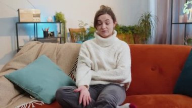 Face palm. Shame on you. Upset woman making disrespect gesture, feeling bored, disappointed in fail results bad news. Portrait of girl at home apartment living room sitting on orange couch. Lifestyles