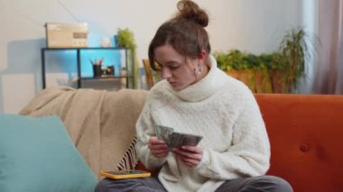 Planlama bütçesi. Para sayan zengin bir kadın akıllı telefon hesap makinesi uygulaması kullanıyor, evdeki faturaları hesaplıyor. Kazancından memnun olan neşeli kız, planlı tatil ve hediyeler için para biriktirir.