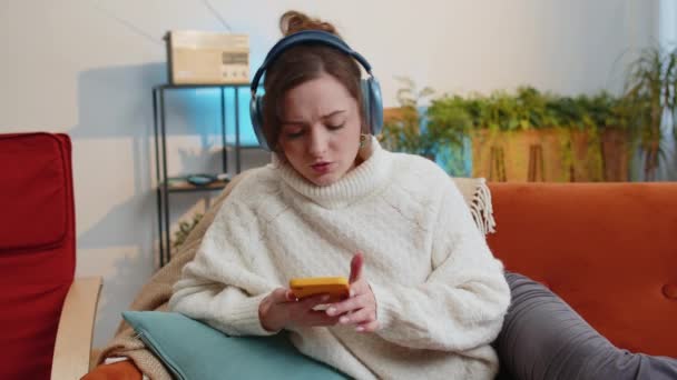 아파트 소파에 헤드폰으로 긴장을 행복해 여성의 활기넘치는 디스코 음악을 듣기로 — 비디오