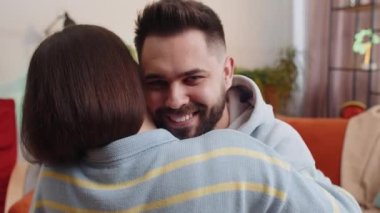 Erkek portresi kucaklayan, sarılan, kameraya bakan bir kadın. Genç otantik aile evliliği çifti. Ortaklık, sevgi dolu duygular. Karı koca birlikte.