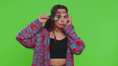 Araştırmacı bilim adamı kadın yüzünün yanında büyüteç tutan, kameraya bakan, büyük zumlanan komik gözlerle araştıran, analiz eden. Krom anahtar arkaplanda izole edilmiş kız, yeşil ekran