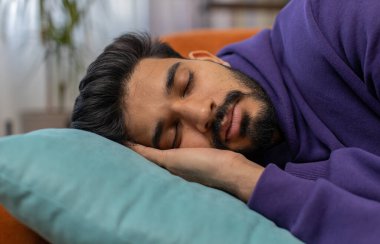 Yorgun Hintli adam yatağa uzanıp dinleniyor. Tasasız genç Hintli adam uyuyordu, evinde yastıklarla rahat bir kanepede uyuyordu. Gözlerini kapadı. Tek başına gündüz uykusunun tadını çıkardı.