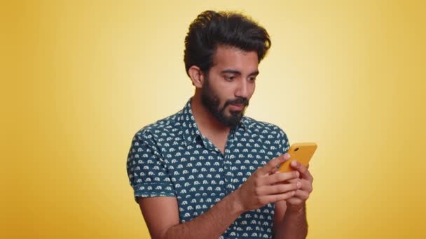 Szczęśliwy Podekscytowany Szczęśliwy Indianin Człowiek Zielonej Koszuli Używać Smartfona Wpisując — Wideo stockowe