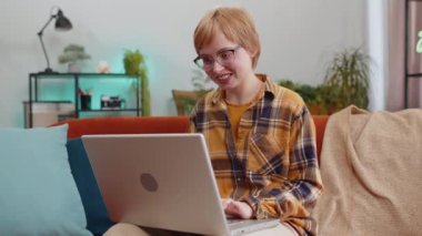 Aman Tanrım. Vay canına. Laptop bilgisayarı kullanan genç bir kadın, iyi haber mesajı alıyor, ani zaferi kutluyor piyango galibiyetini evde online alışveriş yaparak kutluyor. Yaşam tarzı teknolojileri