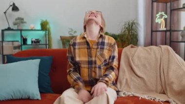 Portrait of happy calm young woman at home couch smiling friendly, glad expression looking away dreaming resting, relaxation feel satisfied concept good news, celebrate win. Girl on living room sofa