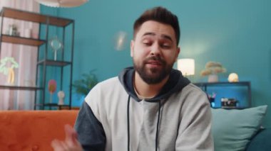 Beyaz adamın kameraya bakan POV 'u, arkadaşları ya da ailesiyle görüntülü kamera konferansı yapıyor, ev odasında keyifli sohbetler ediyor. Kanepede oturan adam gülüyor, el sallıyor.