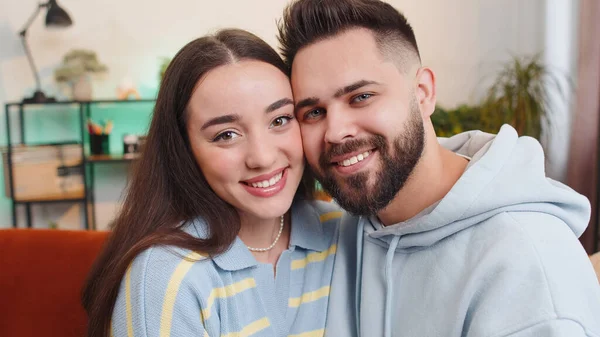 stock image Portrait of happy smiling family marriage couple man woman looking at camera, hugging, embracing cheech to cheech at home. Attractive husband and wife laughing together on sofa in room. Domestic life