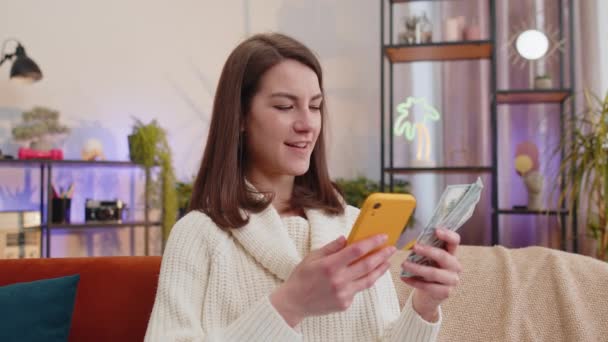 Planowanie Budżetu Rodzinnego Uśmiechnięta Młoda Kobieta Licząca Pieniądze Używająca Smartfona — Wideo stockowe