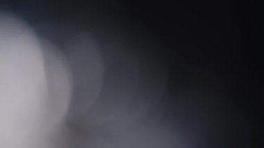 Çok renkli ışık siyah arkaplanda 4K görüntü sızdırıyor. Stüdyoda gaz sızıntısı var. Doğal aydınlatma ışınları bokeh etkisi. Çekimlerinizi birleştirmek, videoyu biçimlendirmek, geçişlerinizi