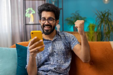 Mutlu Hintli adam cep telefonu daktilo kullanarak 