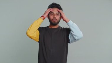 Aman Tanrım, vay canına. Kazanan şaşırır, şaşırır, kameraya büyük gözlerle bakar, ani zaferle şoke olur. Kafası karışmış yakışıklı Hintli adam gri stüdyo arka planında tek başına.