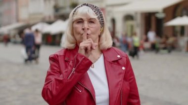 Sessiz olun lütfen. Kıdemli kadın işaret parmağını dudaklarına bastırıyor. Sessiz ol işareti yapıyor. Dışarıdaki dedikoduları kimseye söyleme. Şehir caddesinde yürüyen yaşlı bir büyükanne. Kasaba yaşam tarzları