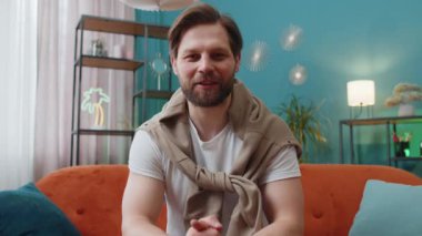 Beyaz adamın kameraya bakan POV 'u, arkadaşları ya da ailesiyle görüntülü kamera konferansı yapıyor, ev odasında keyifli sohbetler ediyor. Kanepede oturan adam gülüyor, el sallıyor.