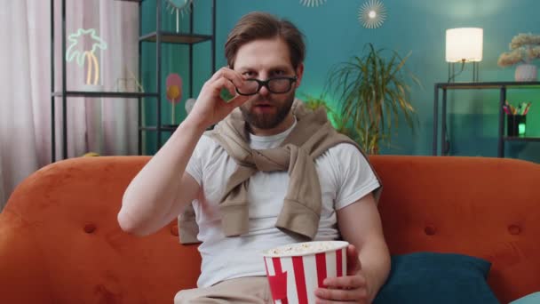 Tânăr Entuziasmat Ochelari Stă Canapea Mâncând Gustări Popcorn Vizionând Joc — Videoclip de stoc