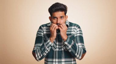 Stressed depressed indian man terrified about danger problems, suffering phobia, anxiety disorder, expresses fear, waving no, insecure, stress, panic. Hindu guy isolated on beige studio background