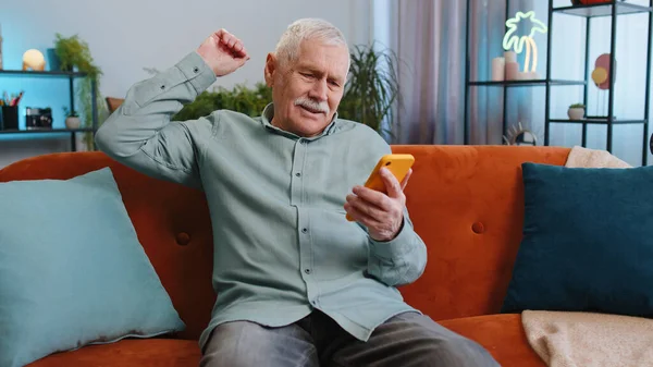Smutne Niezadowolony Starszy Dziadek Człowiek Używać Smartfona Wpisując Przeglądanie Traci — Zdjęcie stockowe