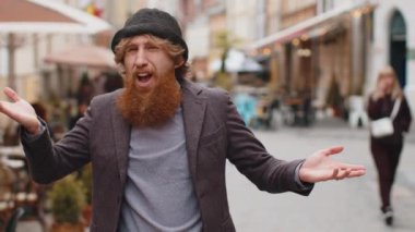 Ne diyecegimi bilmiyorum. Kafası karışmış genç sakallı bir adam belirsiz bir soru hakkında utanmış, kuşkuları var, hiçbir fikri yok, bilgisiz bir kararsız. Şehir caddesinde yürüyen kızıl saçlı adam.