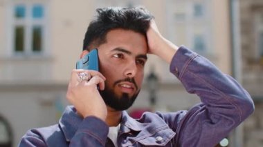 Mutlu sakallı adam telefonda konuşuyor. Şehir caddesinde dolaşan beklenmedik iyi haber dedikoduları. Hintli turist uzaktan iletişim kurarak akıllı telefonla konuşuyor. Şehir yaşam tarzları açık havada