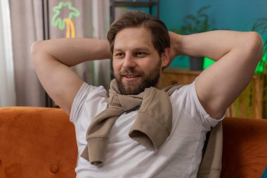 Yorgun bir adam rahat kanepeye uzanıp dinleniyor, gündüz uyukluyor. Kafasının arkasında el ele tutuşan gülümseyen beyaz adamın portresi. Oturma odasında kanepede uyuyakalıyor.