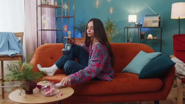 Glücklich Überglückliche Frau Mit Drahtlosen Kopfhörern Entspannt Auf Dem Sofa — Stockvideo