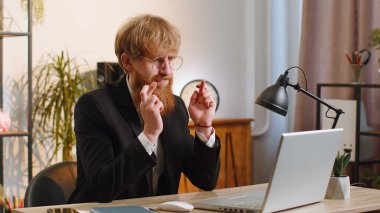 Ev ofisinin bilgisayarında çalışan genç iş adamı ekranda şans diliyor iyi şans diliyor, sınav sonuçları diliyor piyango ikramiyesinde zafer kazanmayı hayal ediyor.