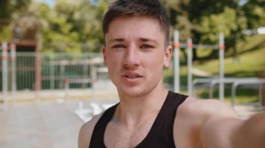 Atletik vücut geliştiricisinin POV selfie 'si video dersleri kaydediyor, sosyal medya için blog blogu. Çocuk parkındaki genç adam spor, sağlık, spor ve spor hakkında konuşuyor. Kuvvet motivasyonu