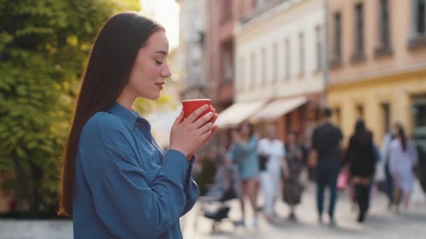 아침에 냄새나는 커피나 밖에서 즐기는 즐거움을 도시를 소녀가 거리에서 햇볕을 — 비디오