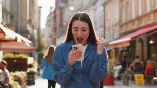 Sorprendido Joven Bonita Mujer Utilizar Teléfono Inteligente Móvil Celebrando Ganar — Vídeo de stock