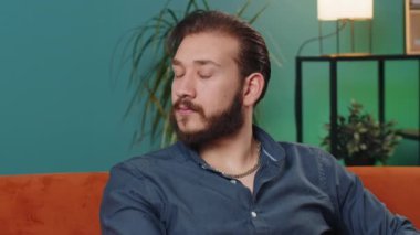 Mutlu, sakin Lübnanlı adamın portresi koltuğunda gülümseyen dostane, mutlu yüz ifadesi başka tarafa bakıyor dinlenme konsepti tatmin olmuş hissediyor iyi haberler, kutlama zaferi. Oturma odasındaki Arap adam.