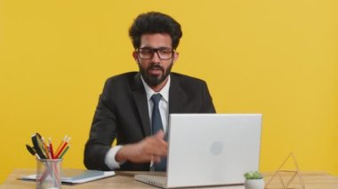 Hintli iş adamının mola, sınır ya da dur işareti vermesinden bıkmış durumdayım. Baskı yok, ofis masasında daha fazla zamana ihtiyacım var. Bilgisayarda çalışan Hintli adam sarı arka planda izole edilmiş.