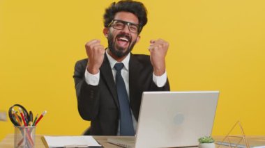 Hindistan 'daki iş adamlarına para yağmuru yağıyor başarıyı kutluyor, kazanıyor, gol başarısı, iyi haber, ofis masasında büyük ikramiye şansı. Kariyer büyür. Hindu adam dizüstü bilgisayarla çalışıyor.