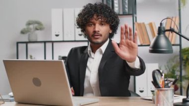 Stop. Indian businessman guy working on laptop, warning of finish, prohibited access, declining communication, body language, rejection, danger trouble. Manager man freelancer at home office workplace