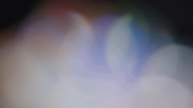 Çok renkli ışık siyah arkaplanda 4K görüntü sızdırıyor. Stüdyoda gaz sızıntısı var. Doğal aydınlatma ışınları bokeh etkisi. Çekimlerinizi birleştirmek, videoyu biçimlendirmek, geçişlerinizi