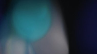Çok renkli ışık siyah arkaplanda 4K görüntü sızdırıyor. Stüdyoda gaz sızıntısı var. Doğal aydınlatma ışınları bokeh etkisi. Çekimlerinizi birleştirmek, videoyu biçimlendirmek, geçişlerinizi