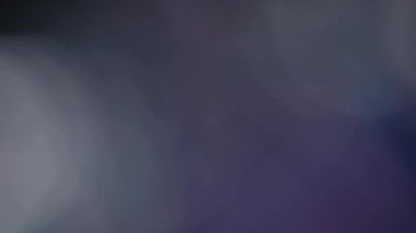 Çok renkli ışık siyah arkaplanda 4K görüntü sızdırıyor. Stüdyoda gaz sızıntısı var. Doğal aydınlatma ışınları bokeh etkisi. Çekimlerinizi birleştirmek, videoyu biçimlendirmek, geçişlerinizi