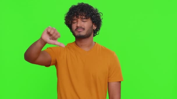 嫌いだ 嫌いを表現し 親指を看板ジェスチャーを示すシャツの中に不幸なインド人の男を動揺 ハンサムな若い男 クロマキーを背景に撮影された屋内スタジオ — ストック動画