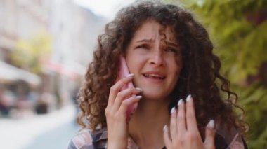 Uzaktan iletişim kuran genç bir turistin portresi akıllı telefonla konuşuyor. Şehir caddesinde yürüyen bir kız beklenmedik bir şekilde iyi haber dedikodusu yapıyor. Şehir yaşam tarzları açık havada