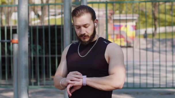 Atletische Libanese Man Sportkleding Met Behulp Van Slim Horloge Luisteren — Stockvideo